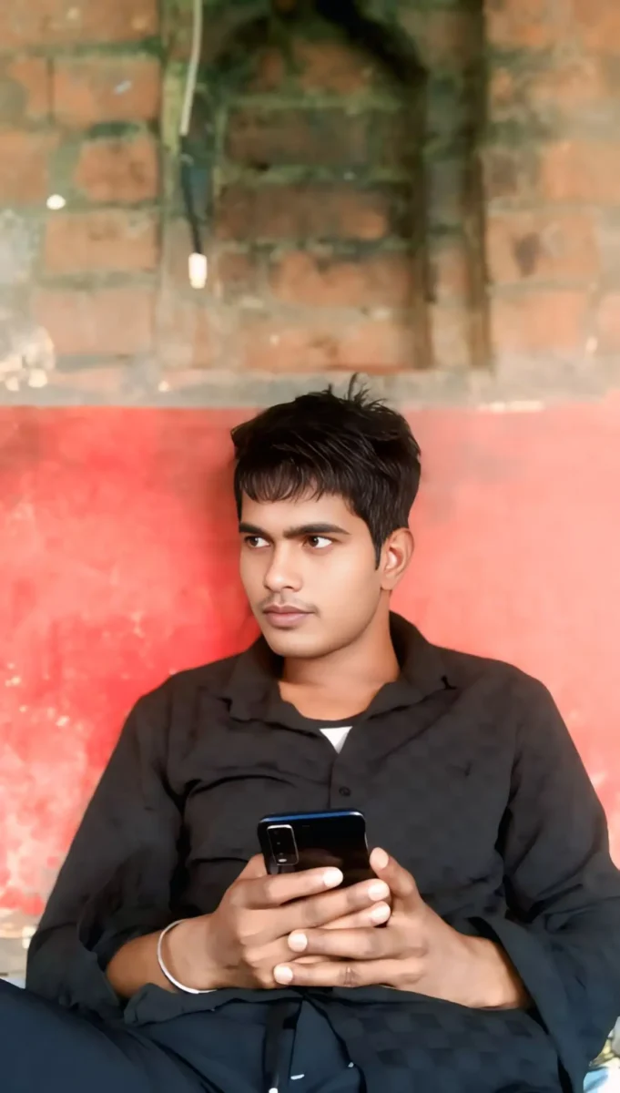 Young Indian man holding a smartphone in a black shirt, used as a reference photo for realistic AI image generation